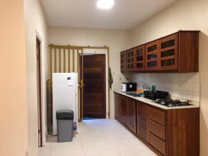 a kitchen with wooden cabinets and a white refrigerator at Grapefruitstraat in Paramaribo