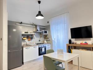 uma cozinha com uma mesa e uma cozinha com um frigorífico em Casa Bolina - Mini appartamento em Taranto