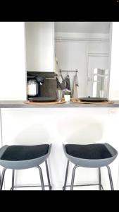 two chairs sitting in a kitchen with a counter at LE COSY studio proche PARIS avec parking & terrasse in Courcouronnes