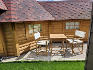 een tafel en stoelen voor een hut bij Chalet Finlandais et Sauna 2 pers in Gosnay