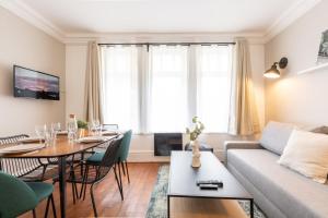 een woonkamer met een bank en een tafel bij Lille Centre - 2BR in the heart of Lille! in Lille