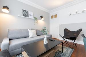 een woonkamer met een bank en een tafel bij Lille Centre - 2BR in the heart of Lille! in Lille