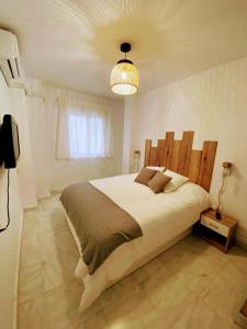 - une chambre avec un grand lit et une tête de lit en bois dans l'établissement 1 Mijas Apartment, à Mijas