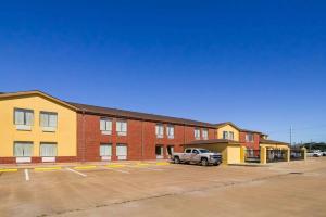 un estacionamiento frente a un edificio con un camión en Quality Inn Bay City TX, en Bay City