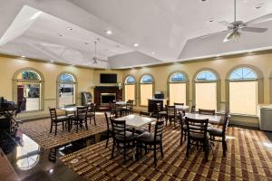 un comedor con mesas, sillas y ventanas en Quality Inn Bay City TX, en Bay City