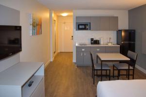 a kitchen and dining room with a table and chairs at MainStay Suites MSP Airport - Mall of America in Bloomington