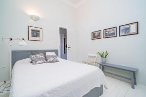 Dormitorio blanco con cama y mesa azul en Apartment Ranieri Pile, en Dubrovnik