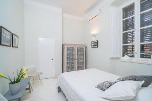 1 dormitorio blanco con 1 cama y 1 silla en Apartment Ranieri Pile, en Dubrovnik