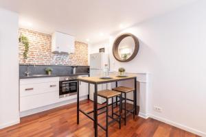 cocina con mesa y espejo en la pared en Old Lille - studio ideally located !, en Lille