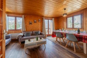 a living room with a couch and a table at Grand Appartement dans Chalet Serre Chevalier à 8 minutes des pistes in Saint-Chaffrey