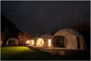 three domes in a field at night at The Crystal Resort in Hundar