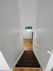 una escalera con una señal de salida verde en un edificio en The Silver City Hotel en Immingham