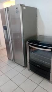 uma cozinha com um frigorífico de aço inoxidável e um fogão em Casa de campo agradável com piscina aquecida em Juatuba