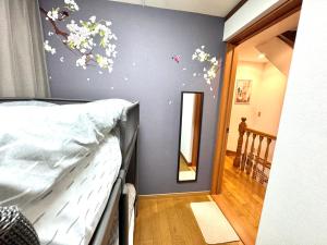 a bedroom with a bed with flowers on the wall at 3 Best location small private room!cozy place in JUJO shopping street in Tokyo