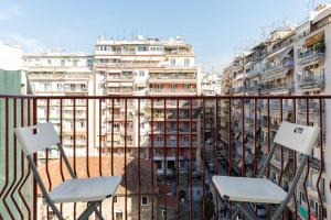 Duas cadeiras numa varanda com vista para os edifícios em #Alice by halu! Apartments em Tessalônica
