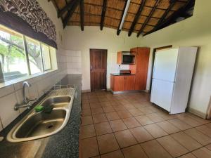 a kitchen with a sink and a refrigerator at Lama Lama Game Reserve in Mount Hope