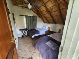 a bedroom with two beds and a ceiling at Lama Lama Game Reserve in Mount Hope
