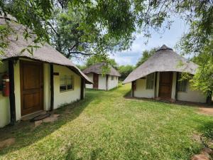 a row of houses with thatched roofs at Lama Lama Game Reserve in Mount Hope