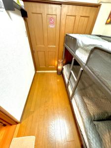 an empty bunk bed in a room with a wooden floor at 3 Best location small private room!cozy place in JUJO shopping street in Tokyo