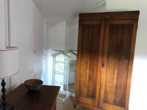 a wooden cabinet in a room with a table at Walking distance from Via Veneto in Rome