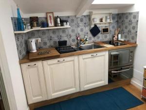 eine Küche mit weißen Schränken und einer Spüle in der Unterkunft Walking distance from Via Veneto in Rom + 3 Fotos