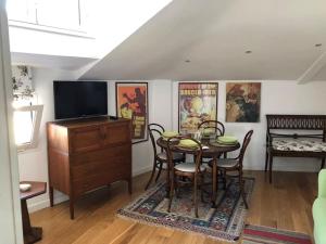 ein Esszimmer mit Tisch und Fernseher in der Unterkunft Walking distance from Via Veneto in Rom