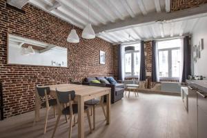 un soggiorno con tavolo e muro di mattoni di Old Town - Superb apartment in rue Esquermoise ! a Lille