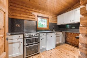 uma cozinha com electrodomésticos brancos e um tecto de madeira em Kingfisher Lodge and mooring on the River Ouse em Renhold