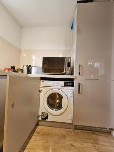 a kitchen with a washing machine and a refrigerator at Cosy & Stylish One-Bed Flat-close to Warwick Uni in Coventry