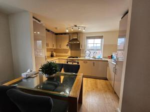 a kitchen with a table and a dining room at Cosy & Stylish One-Bed Flat-close to Warwick Uni in Coventry