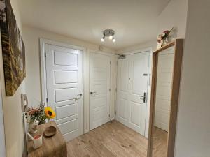 a hallway with white doors and a vase of flowers at Cosy & Stylish One-Bed Flat-close to Warwick Uni in Coventry