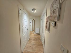 a hallway with a white door and a tile floor at Cosy & Stylish One-Bed Flat-close to Warwick Uni in Coventry