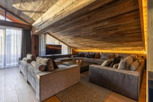 ein Wohnzimmer mit 2 Sofas und einem TV in der Unterkunft Hotel Meta Resort & Vine SPA in Szczyrk