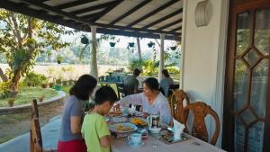 a group of people sitting at a table eating food at Ella Nature valley homestay in Ella