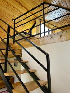 drewnianych schodów w budynku z drewnianym sufitem w obiekcie Borjomi inn Cottages w Bordżomi