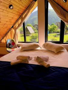 łóżko w pokoju z dużym oknem w obiekcie Borjomi inn Cottages w Bordżomi