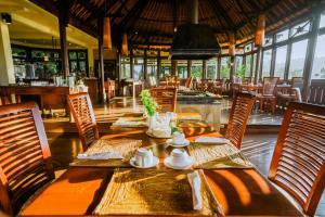 Bagus Jati Health & Wellbeing Retreat في تيغالالانغْ: غرفة طعام مع طاولة وكراسي في مطعم