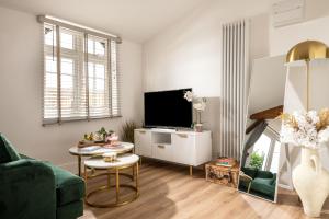 a living room with a green couch and a tv at Stargaze in Blandford Forum