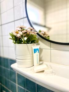 ein Waschbecken im Bad mit einem Blumentopf und einem Spiegel in der Unterkunft Madinaty Luxury Apartments New cairo in Madinaty