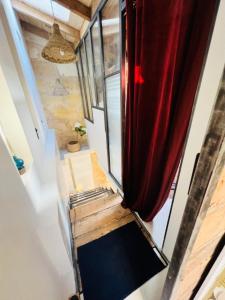 洛爾蒙的住宿－The Hidden Gem Of Bordeaux，一个小房子,有楼梯和红色窗帘