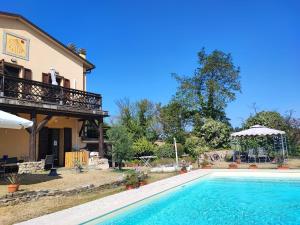 皮亚诺罗Pizzicalaluna Agriturismo Olistico sulle Colline di Pianoro的一栋房子前面有游泳池的别墅