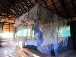 a bedroom with a canopy bed in a hut at Sukulu Reserve in Livingstone