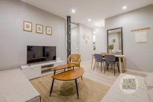uma sala de estar com um sofá e uma mesa com cadeiras em Acogedor Apt 3 habitaciones y terraza en el Centro de Madrid em Madrid