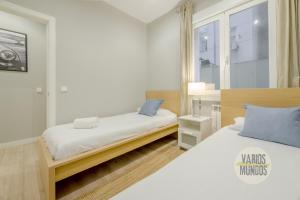 um quarto branco com 2 camas e uma janela em Acogedor Apt 3 habitaciones y terraza en el Centro de Madrid em Madrid