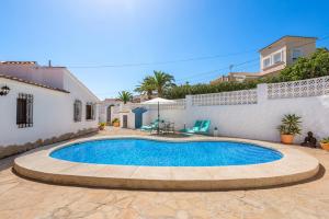 a swimming pool in a yard next to a house at Villa Maeva - PlusHolidays in Casas de Torrat