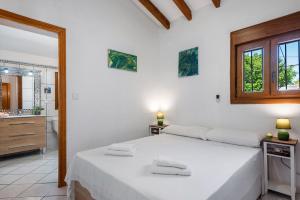 a white bedroom with a bed and a bathroom at Villa Maeva - PlusHolidays in Casas de Torrat +27 photos
