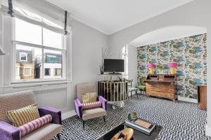 ロンドンにあるLondon Chelseaのリビングルーム(紫色の家具、テレビ付)