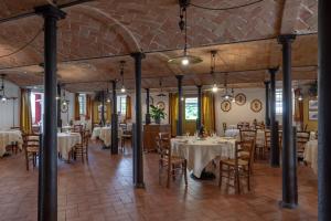 a dining room with white tables and chairs at Agriturismo Cavazzone in Regnano