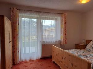 ein Schlafzimmer mit einem Bett und einem großen Fenster in der Unterkunft Apartment in Fügenberg/Zillertal 727 in Pankrazberg