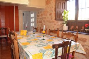 a dining room table with a table cloth and candles on it at La Antigua, casa céntrica, amplio patio y barbacoa in Campillo de Altobuey